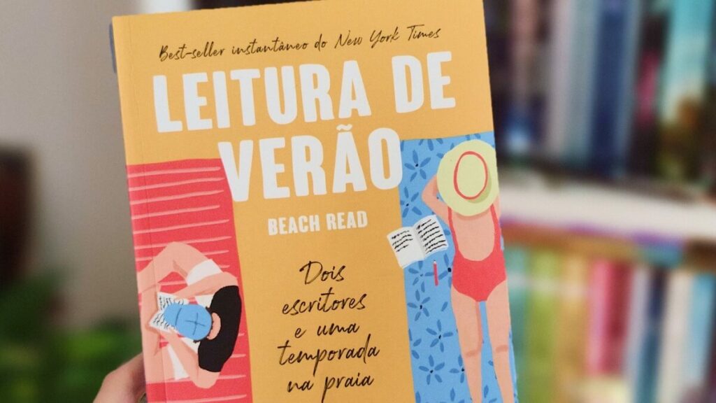 Pessoa segurando o livro Leitura de Verão com uma estante de fundo