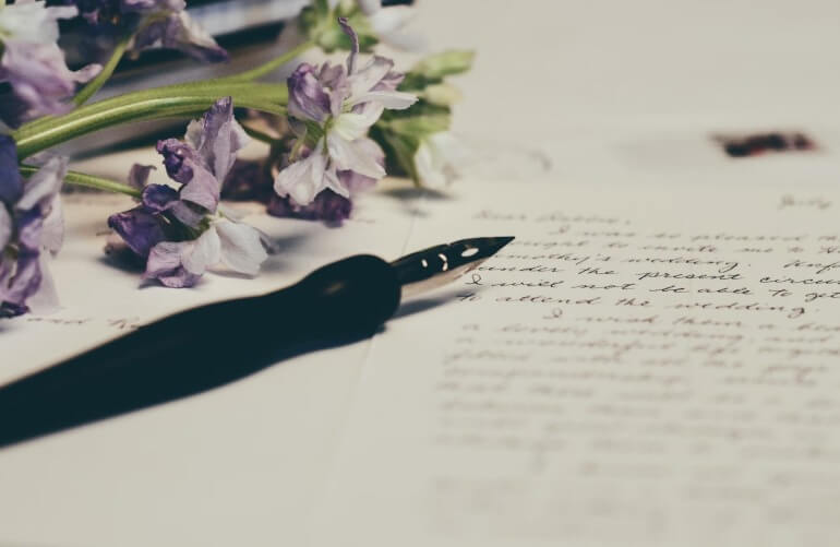 Foto de uma carta escrita a mão e uma caneta tinteiro