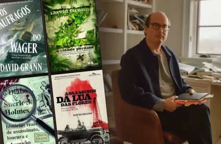 David Grann ao lado das capas de seus livros, incluindo "Assassinos da Lua das Flores", "Os Náufragos do Wager" e "Z: A Cidade Perdida"