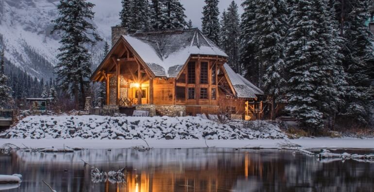 Casa isolada na neve próxima de um lago